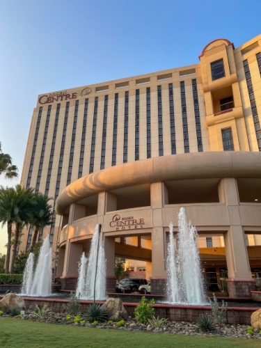 The front of Rosen Centre hotel at sunset, with fountains in the foreground.