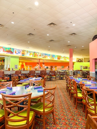 A room with colorful wall paint and murals set with dozens of tables with wooden chairs. Enjoy an Easter brunch at Rosen Centre.