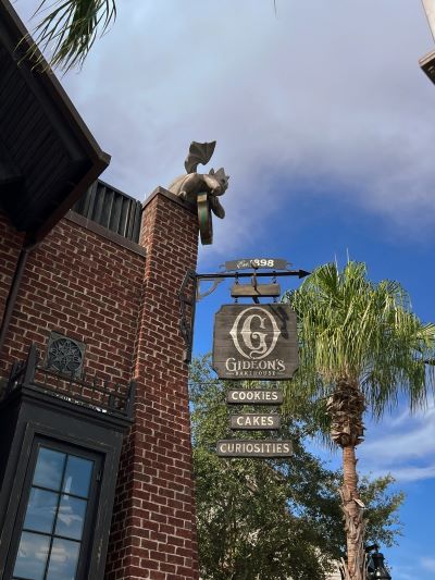 A wooden sign on a brick building that reads Gideon's Bakehouse, Cookies, Cakes, Curiosities. Gideon's Bakehouse is located in Disney Springs, a great place to unwind in Orlando.